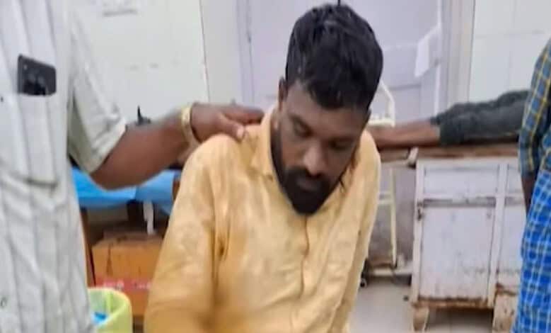 Man receiving medical attention in a clinical setting with healthcare workers present.
