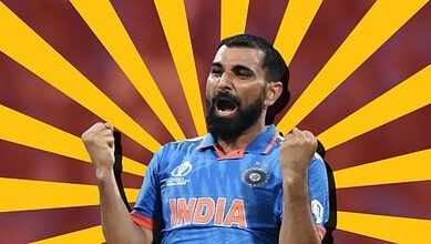 Indian cricket player celebrating with fists raised, wearing blue jersey with 'India' logo.