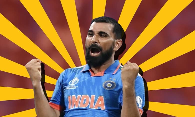 Indian cricket player celebrating with fists raised, wearing blue jersey with 'India' logo.