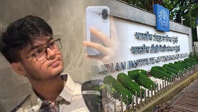 Young boy with glasses taking a selfie in front of the Indian Institute of Technology sign.