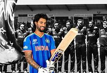 Indian cricketer Tilak Varma holding a cricket bat with team behind him in black and white.