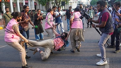 Women journalists protesting, some being detained by police on the street.