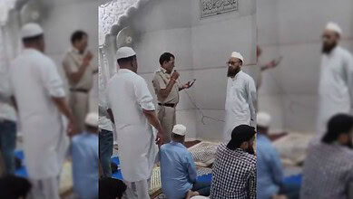 Muslim men praying outside a mosque in Delhi, India, during daytime.