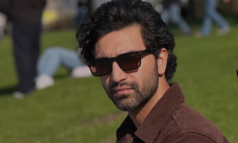 Pakistani actor Ahad Raza Mir wearing sunglasses outdoors in a park setting.