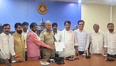 Group of men, including police officer, at a formal meeting in a conference room.