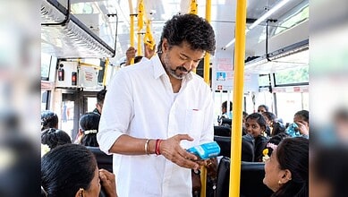 Man in white shirt making contactless payment on bus with children around him.