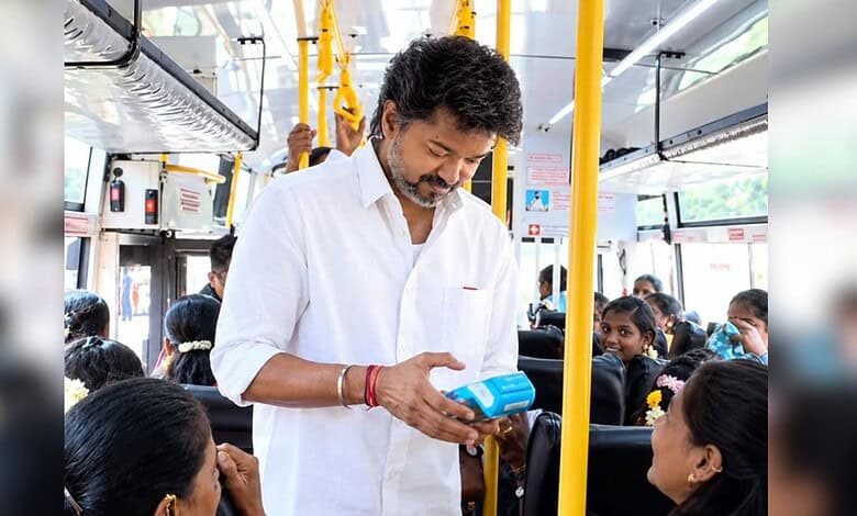 Man in white shirt making contactless payment on bus with children around him.