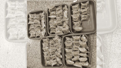 Multiple packages of seized cannabis with handwritten labels in plastic bags at RGI Airport.