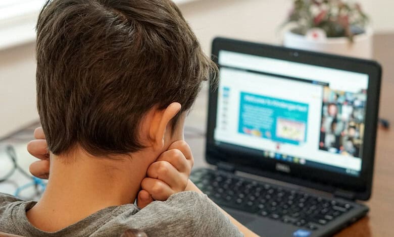Young student engaged in online learning on a laptop at home.