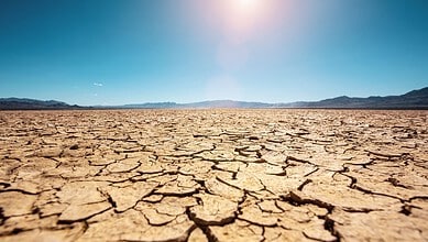 Cracked, dry land under a bright sun in Telangana due to drought.
