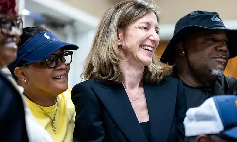 Diverse group of people smiling and engaging at a political event, highlighting veteran issues and US-Her.