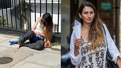 Woman sitting on sidewalk with toddler, looking down, in an urban setting.