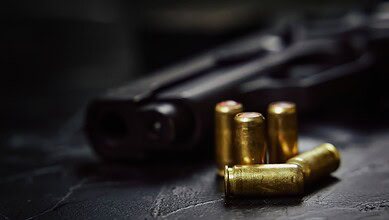 Firearm with bullets on a dark surface, related to shooting incident in Hyderabad.