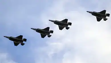 Four fighter jets flying in formation against a cloudy sky.