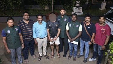 Police officers and suspect in drug bust operation, Goa-Hyderabad network, arrest scene.
