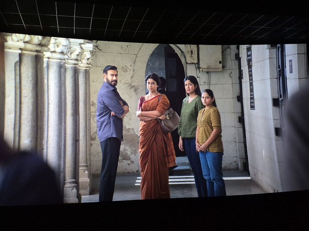Four people standing outside a historic building, engaged in conversation.