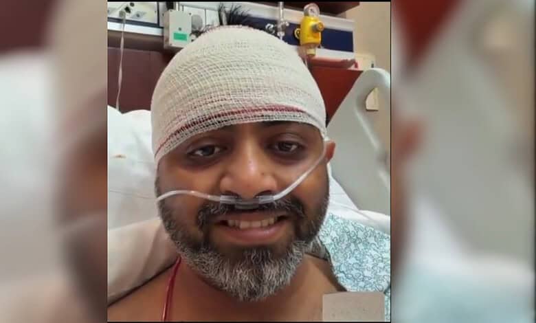 Injured Indian pilot Smit Machchhar smiling in hospital bed with bandage and oxygen tube.