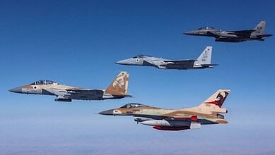 Israeli fighter jets flying in formation in clear blue sky.