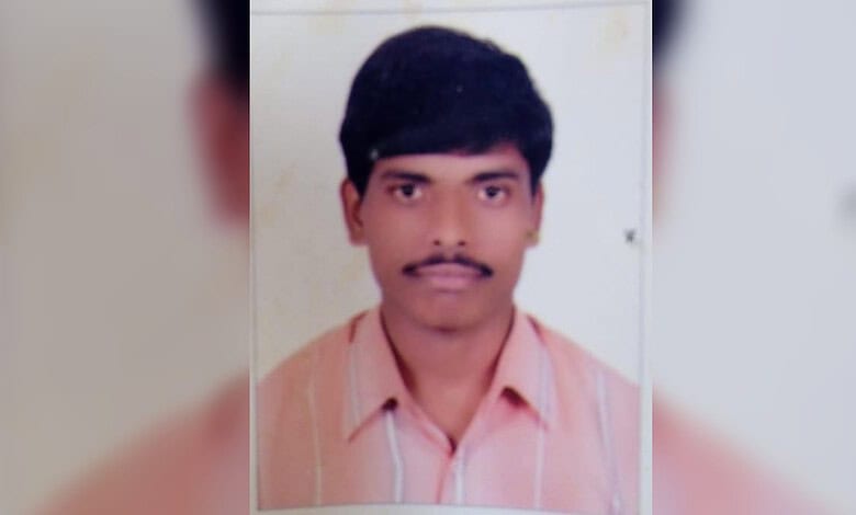 Jagtial man with black hair and mustache, wearing a pink shirt, looking at the camera.