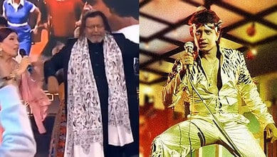Mithun Chakraborty performing on stage in a yellow outfit with a microphone.