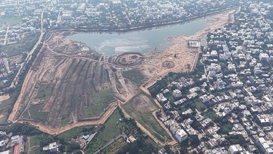 Aerial view of a city with a large water body and surrounding construction areas.