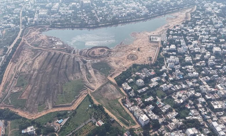 Aerial view of a city with a large water body and surrounding construction areas.