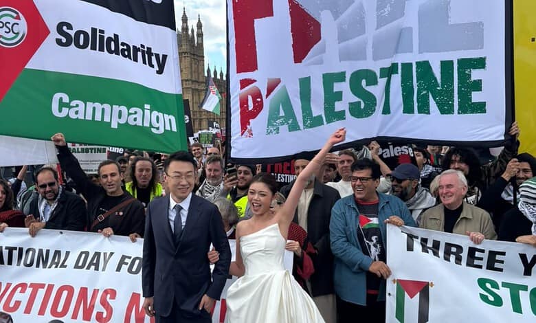 Newlywed couple poses with demonstrators holding Palestine banners in London.