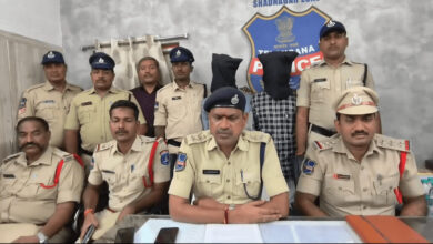 Police officers and a suspect with a hood in front of a police badge at Future City police station.