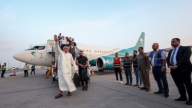People gather around an aircraft at Najaf Airport after flights resumed.