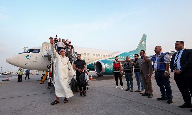 People gather around an aircraft at Najaf Airport after flights resumed.