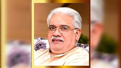 Respected Indian education leader in Kuwait with white hair and glasses, smiling in traditional attire.