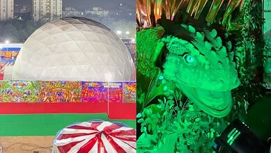 Colorful carnival scene with a large geodesic dome and a green-lit dinosaur figure.