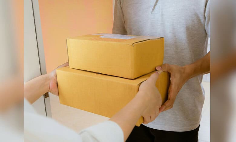 Person handing over two yellow parcels to another individual.