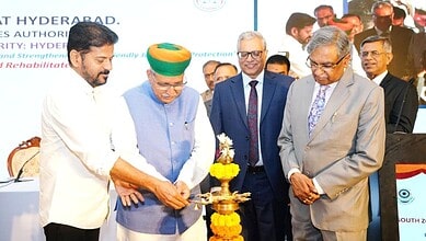 Indian and officials light a traditional lamp at a formal event in Hyderabad.