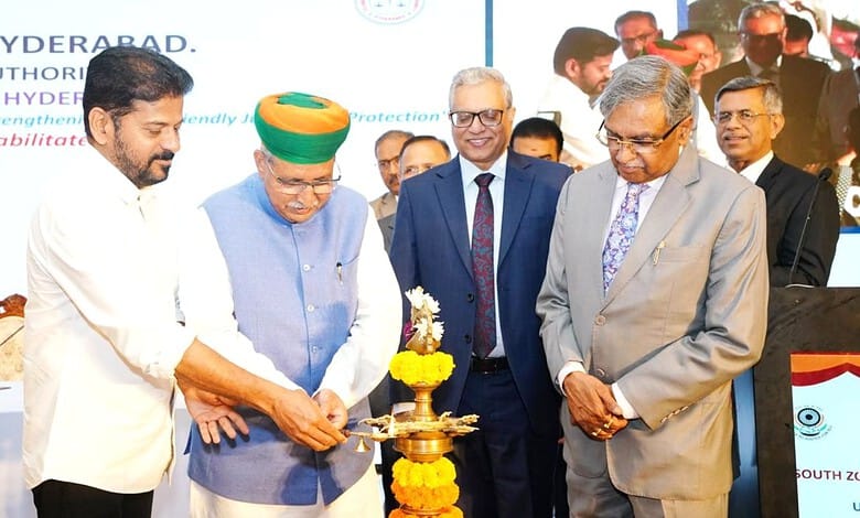 Indian and officials light a traditional lamp at a formal event in Hyderabad.