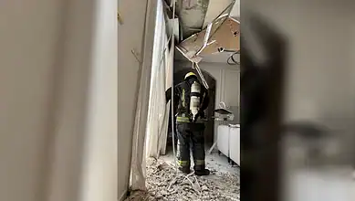 Firefighter inspecting damage after missile debris impact in Riyadh.