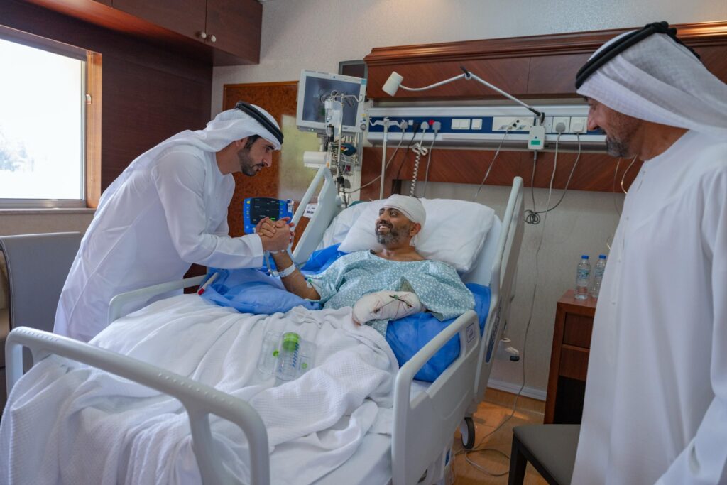 Sheikh Hamdan holds injured flydubai pilot Smit Machchhar’s hand in hospital.