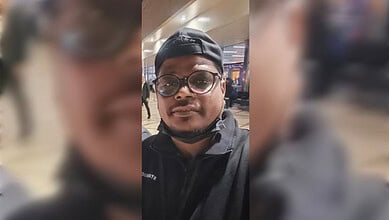 Man wearing glasses and cap at Riyadh airport, critically injured, in a selfie.