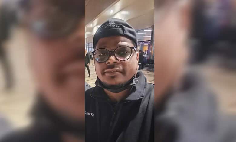 Man wearing glasses and cap at Riyadh airport, critically injured, in a selfie.