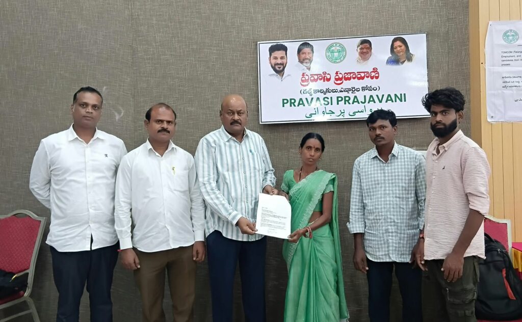 Group of people, including a woman in a green saree, at a formal event in Telangana.