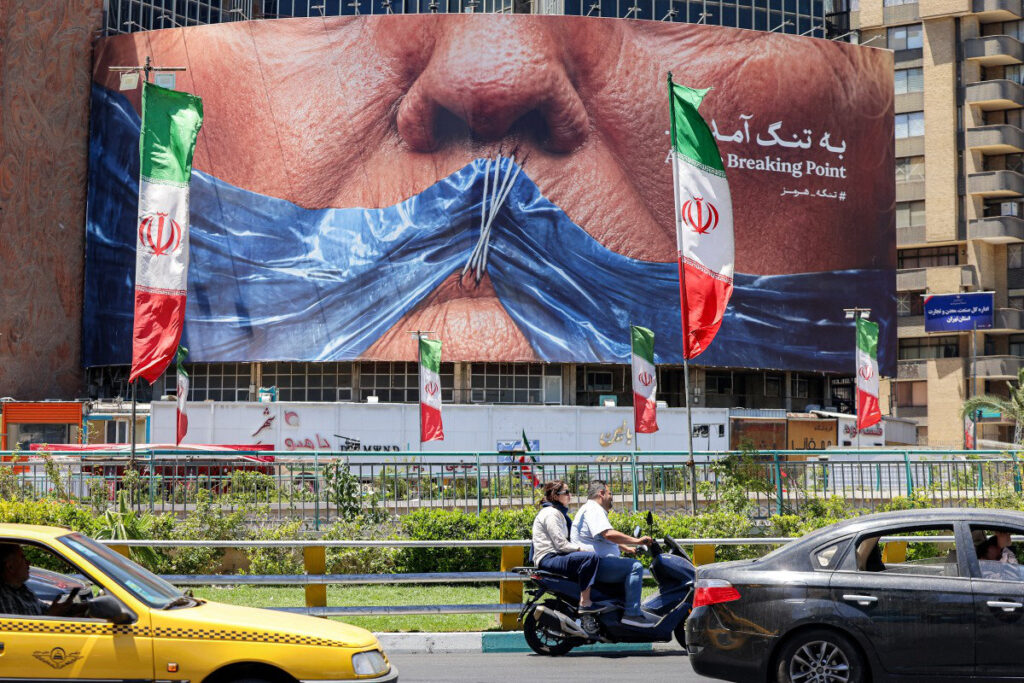 Political billboard featuring Donald Trump and the Strait of Hormuz in Tehran.