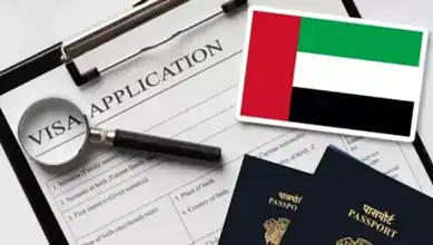 Magnifying glass over visa application form with UAE flag and passports.
