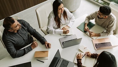 IT professionals discussing work and emergencies during a meeting in Hyderabad office.