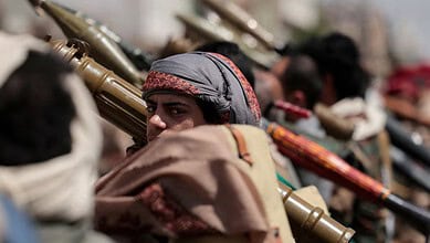 Houthi fighters in Yemen armed with rifles and wearing traditional head coverings.